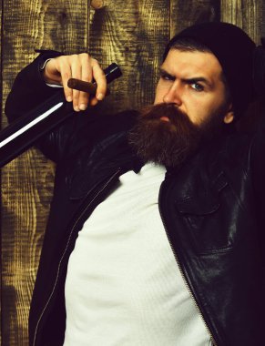 Sakallı, Kafkas hippisi elinde şişe, puro içiyor.