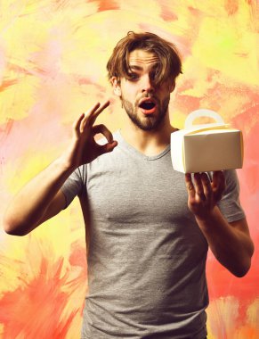 Kafkas sakallı seksi maço adam yemek kutusu tutuyor.