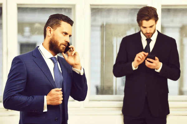 Hombres o hombres de negocios hablando por teléfono móvil cerca de la ventana — Foto de Stock