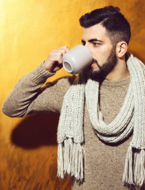 Sakallı adam çay içiyor, fincandan kahve içiyor.