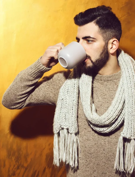 Бородатый человек пьет чай, кофе из чашки с серьезным лицом — стоковое фото