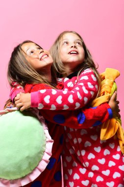 Pijama partisi ve çocukluk konsepti. Gevşek saçlı kızlar sarılır