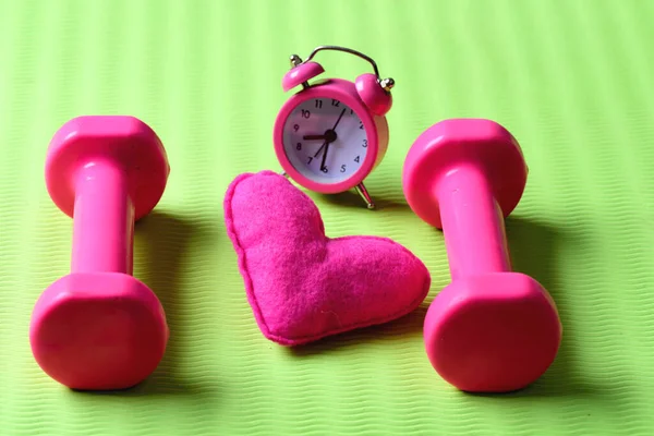 Conceito de treino matinal. halteres na cor rosa perto do despertador — Fotografia de Stock