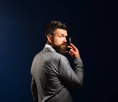 Koyu mavi arka planda aldatıcı yüzü olan bir iş adamı..