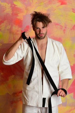 Renkli arka planda ciddi yüzü ve tüyleri olan bir adam.