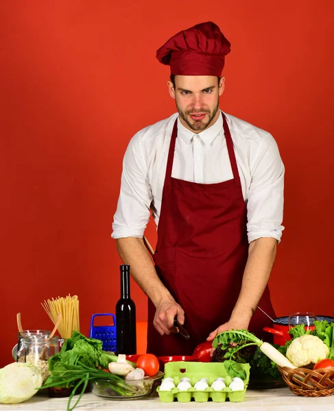 Chef med leende ansikte håller kniv och röd paprika — Stockfoto