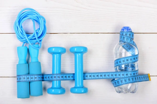 Centimeter tied around gym tools on white backdrop