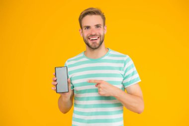 Cep telefonu servisi. Bedava internet. Uygulama akıllı telefonu. İndirin ve oynamaya başlayın. Akıllı telefonu işaret eden adam. Gösterişli bir jest. İşaret parmağı. Reklam için işaret. Dijital teknoloji