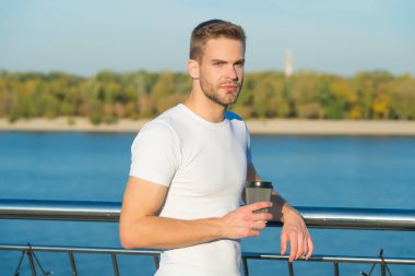 Kahveyi yanına al. Genç adam dışarıda kahve içer. Yakışıklı adam servis bardağını tut. Riber kıyısında bekâr bir adam. Sıradan tarzda traşsız bir adam. Yazlık gardırop. Moda ve tarz