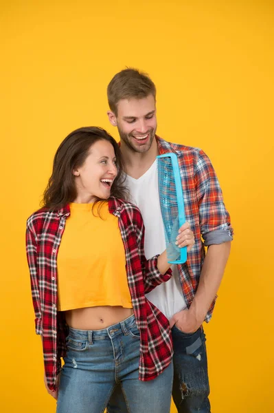 Byt frisyr. Hårvård hemma. Hjälper till med frisyren. Par som har kul med stor kam. Kamma och borsta håret. Man och kvinna tar hand om håret själva. Frisörtjänster. Kreativt humör — Stockfoto