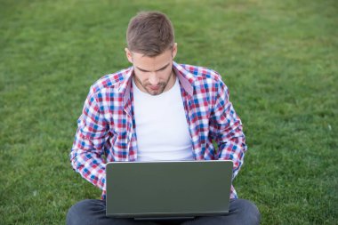 Modern teknolojiler. Öğrenci çayır üzerinde çalışıyor. Çevrimiçi iletişim. İnternette sörf yapmak. Dizüstü bilgisayara bakan adam. Yetenekli geliştirici. İş kurma. Millennial iş yaratıyor. Modern iş