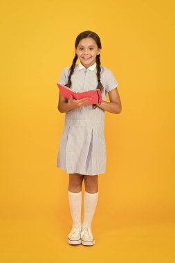 Çocukluk anıları. çocuklar için ansiklopedi kitap. kız edebiyat seviyorum. eski okul. retro üniformalı mutlu küçük kız. vintage çocuk moda. Okula geri dön. küçük kız tutun çalışma kitabı veya not defteri