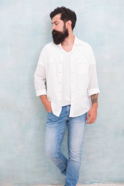 Erkekler için stil ipuçları. Yakışıklı, çekici bir hippi. Moda erkek modeli. Sakallı, olgun bir hippi. Vahşi adamın kumral saçları var. Seksi bir adamın portresi. Kot tarzı. Kentsel bağlamda genç sakallı model