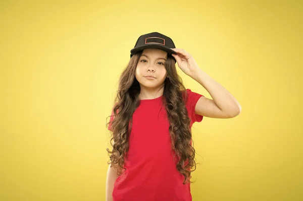 All girls are gorgeous. kid fashion. happy girl in trendy hipster cap. hipster child on yellow backdrop. happy childhood. beauty and fashion. small girl with long hair. cool girl with long curly hair — Stock Photo, Image