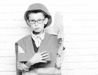 Beyaz tuğladan duvar altyapısı olan yakışıklı bir çocuk.