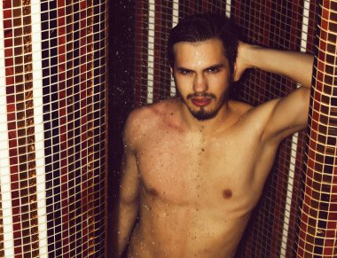 Yakışıklı kaslı seksi adam duşta yıkanıyor.