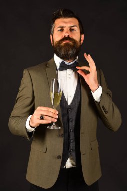 Gururlu yüzü ve köpüklü içeceği olan iş adamı papyonu düzeltir.