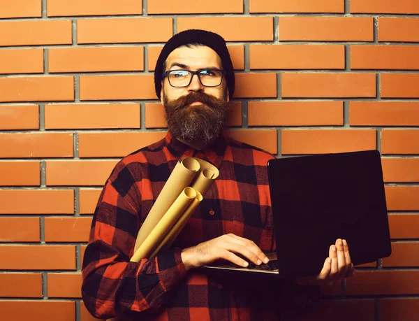 Skäggig brutal kaukasisk hipster med bärbar dator och hushållspapper — Stockfoto