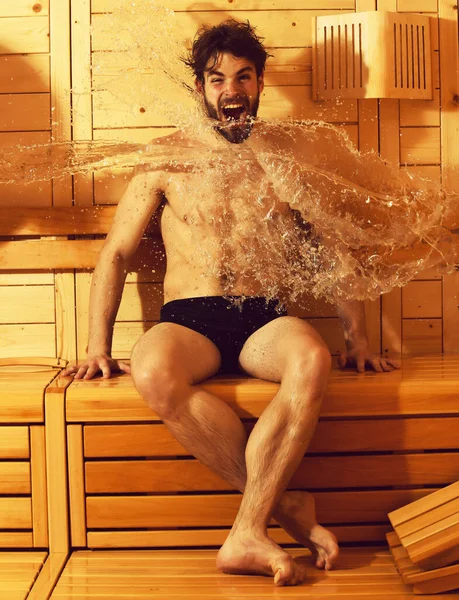Splash van water op opgewonden man op houten achtergrond — Stockfoto