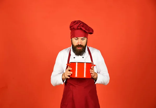 Chef met rode ovenschotel of steelpan. Begrip keukengerei. — Stockfoto