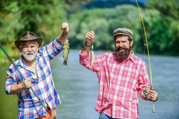 Reunited and it feel so good. father and son fishing. summer weekend. mature men fisher. hobby and sport activity. Trout bait. two happy fisherman with fishing rods. male friendship. family bonding — Stock Photo, Image