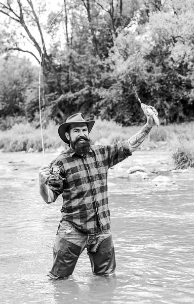 Hora do passatempo. pescador mostrar técnica de pesca usar haste. Fim de semana. Feliz pesca com mosca. pescador barbudo na água. hobby e atividade esportiva. homem maduro voar pesca. homem captura peixe — Fotografia de Stock