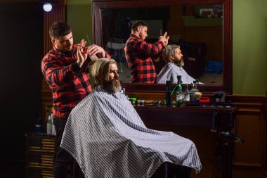 Profesyonel kozmetik. Hippi saç tıraşı oluyor. Sağlıklı saçlar. Sinir bozucu berber kulağına zararlı gelebilir. Bağış ve yardım konsepti. Saçları boyalı adam. Saç kes. Berber berber dükkanı.