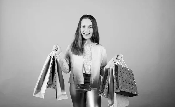 Happy child in shop with bags. Shopping day happiness. Buy clothes. Birthday girl shopping. Fashion boutique. Fashion trend. Fashion shop. Little girl with bunch packages. Fashion girl customer — Stock Photo, Image