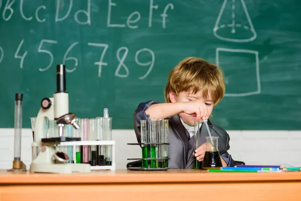 Kunskapskoncept. Fascinerande ämne. Kunskapsdagen. Grabben studerar biologi kemi. Pojkmikroskop och provrör i klassrummet. Grundläggande kunskaper i grundskolan. Utbildningsexperiment — Stockfoto