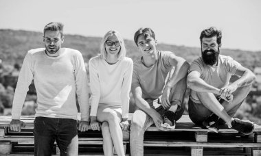 Sadece gülümse. Mutlu erkekler ve kızlar rahatlayın. Dört kişilik bir grup. İzin günü için harika bir yer. Sıradan giyinmiş bir grup insan. Çeşitli gençler birlikte konuşuyor. En iyi arkadaşlar. Yaz tatili