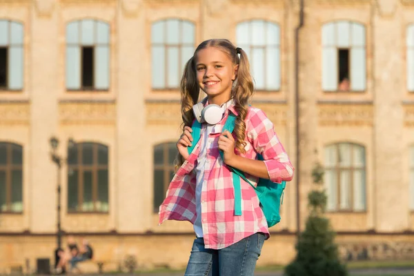 Słoneczny poranek na podwórku. Szczęśliwego beztroskiego dziecka. Zajęcia szkolne. Mała dziewczynka z plecakiem. Życie szkolne. Uczeń. Nowoczesna edukacja. Wesoła nastolatka słuchająca muzyki. Uczennica idzie do szkoły — Zdjęcie stockowe