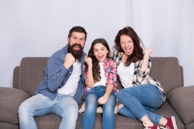 Evde kal. Aile kanepeye oturur. Mutlu baba, anne ve kız. Karantina ve tecrit kavramı. Gülümseyen aile. Birliktelik bizim gücümüz. Sonunda hafta sonu. Küçük kız ailesiyle rahatlıyor.