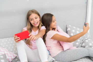 Ama önce bir selfie çekeyim. Pijamalı Selfie kızları. Küçük çocuklar akıllı telefonlarıyla selfie çekerler. Küçük çocuklar kameralı telefona poz veriyor. Yatmadan önce selfie çekimi. Sosyal ağ
