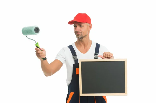 Useful tips. Chalkboard copy space. Paint rolling. Decorator hold paint roller. Renewal and redecorating. Professional equipment. Mature man in cap. Wall painter. Paint shop. Renovation and repair — Stock Photo, Image