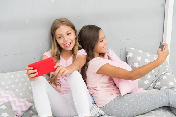 But first let me take a selfie. Selfie girls in pajamas. Small children take selfie with smartphone. Little kids pose to camera phone. Selfie session before bed. Social network