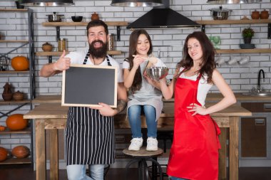 Ailesi mutfakta yemek yapan bir çocuk. Aile hazırlığı bayram yemeği. Haftalık menümüz. Yemek pişirmek. Pasta yapıyorum. Kurabiye pişirmek. Aşçılık okulu. Anne baba ve kızı birlikte yemek pişiriyor.