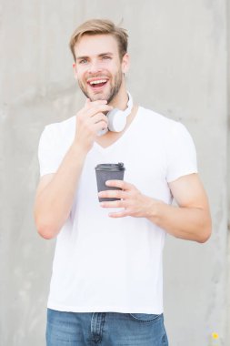 Enerji ve iyimserlik. Mutlu adam sıcak bardağı dışarıda tutuyor. Çay ya da kahvenin tadını çıkarıyorum. Kafein ve enerji molası veriyoruz. Lezzetli enerji içeceği. Sabahları enerji arttırıyorum. Moda müzik aksesuarı