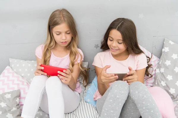 We zijn meer verbonden dan ooit. Kleine kinderen gebruiken mobiele telefoon in bed. Mobiele communicatie. Mobiele communicatie. Communicatietechnologie. SMS communicatie. Het moderne leven — Stockfoto