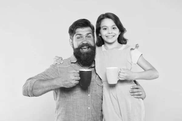 Kafe je obejmutí v hrnku. Malá dcera a otec drží šálky kávy. Šťastnou rodinu baví pít kávu společně. Ranní drink. Čas na snídani. Káva umožňuje vše možné — Stock fotografie