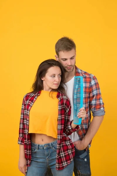 Creative mood. Change hairdo. Hair care at home. Helping with hairstyle. Couple having fun with big comb. Combing and brushing hair. Man and woman taking care hair themselves. Hairdresser services — Stock Photo, Image