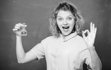 Kimya dersi. Kadın öğretmen ampul ve sıvıyla deney yapıyor. Kimya laboratuvarı. İlginç ve büyüleyici. Kimyayı keşfet. Kimyasal reaksiyon tebeşir tahtası geçmişini izleyen kız