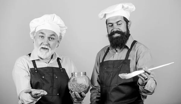 Chef-koks koken. Vader en zoon culinaire hobby. Familie restaurant. Geselecteerde ingrediënten. Zelfgemaakte maaltijd. Maak eten klaar. Culinair recept. Culinair boek. Volwassen bebaarde mannen professioneel restaurant koks — Stockfoto