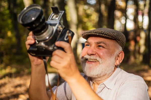 Configurações manuais. Passatempo da pensão. Fotógrafo experiente e qualificado. Velho atira na natureza. Cameraman ao ar livre. Fotógrafo profissional. Paisagem e natureza foto. Velho fotógrafo filmando — Fotografia de Stock