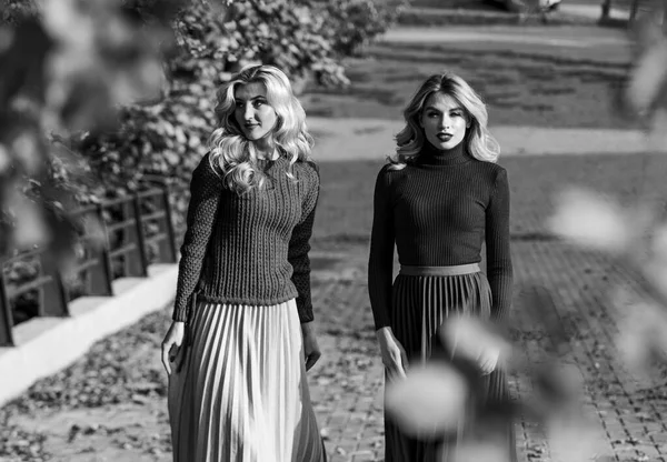 Friends girls. Autumn stylish outfit. Adorable ladies enjoy sunny autumn day. Fashionable clothes. Femininity and tenderness. Fall fashion. Pleated skirt fashion trend. Women walking in autumn park — 스톡 사진