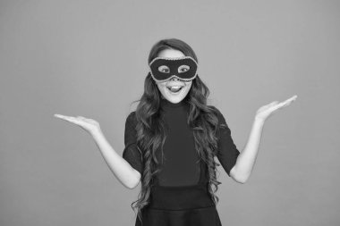 Ürün reklamı. Karnaval maskeli mutlu kız mal için boş eller gösteriyor. Ürünü sunuyorum. Ürün tanıtımı. Tatil indirimi ya da indirim. Tanıtım ve pazarlama, kopyalama alanı
