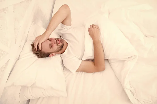 Limitați activitățile în pat. Tipul a avut o noapte nedormită. conceptul de sănătate masculină. Conceptul de pace. Omul obosit doarme în pat. Trezeşte-te dimineaţa devreme. Omul doarme dormitor alb. week-end confortabil acasă. timp pentru relaxare — Fotografie, imagine de stoc