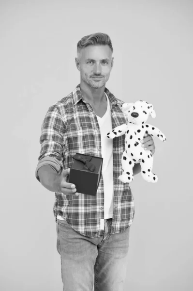 Handsome man with gift box and dog toy. happy valentines day. best birthday present. toy shop. happy holiday shopping. present for her. man made nice purchase. cyber monday concept — 스톡 사진