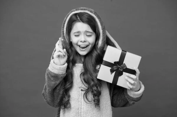 Hope for the best. Girl in bunny pajamas. Child in rabbit kigurumi. Happy girl in cute pajamas. Lifestyle concept. Rest and relax. Child in pajamas hold wrapped gift box. Shop and shopping concept — Stock Photo, Image