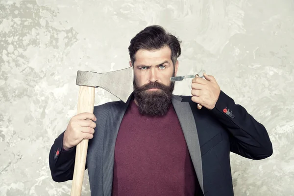 Uma arma velha. Penteado de barbearia. Masculinidade e brutalidade. Barbearia vintage. Barbeiro brutal. Conceito ousado de barbeiro. Homem hipster com machado. Machado afiado e navalha reta. Ferramentas adequadas. Métodos brutos — Fotografia de Stock