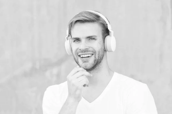 Навушники підходять для розміру голови. Щасливий хлопець носить навушники сірого кольору. Красивий чоловік посміхається вушними стерео навушниками. Сучасний дизайн навушників. Нова технологія. Живе життя вголос — стокове фото